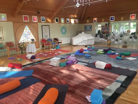 Yoga mats, bolsters and blocks set out on colourful rugs